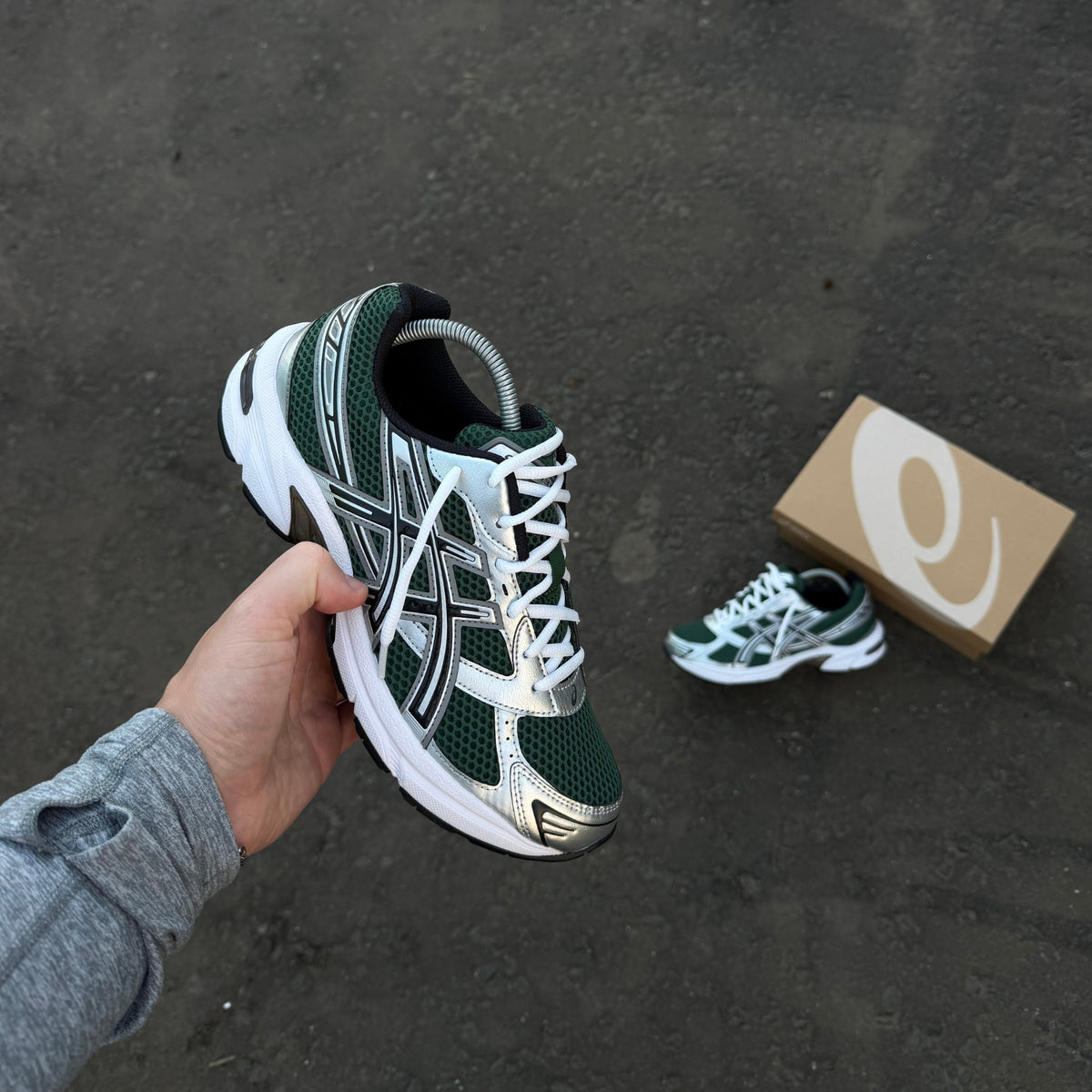 ASICS GEL-1130 Evergreen Black trainers showing lateral side profile, layered silver overlays and white midsole