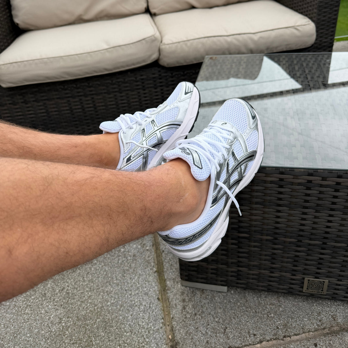Side profile of ASICS Gel-1130 White Pure Silver held by hand highlighting the layered technical upper