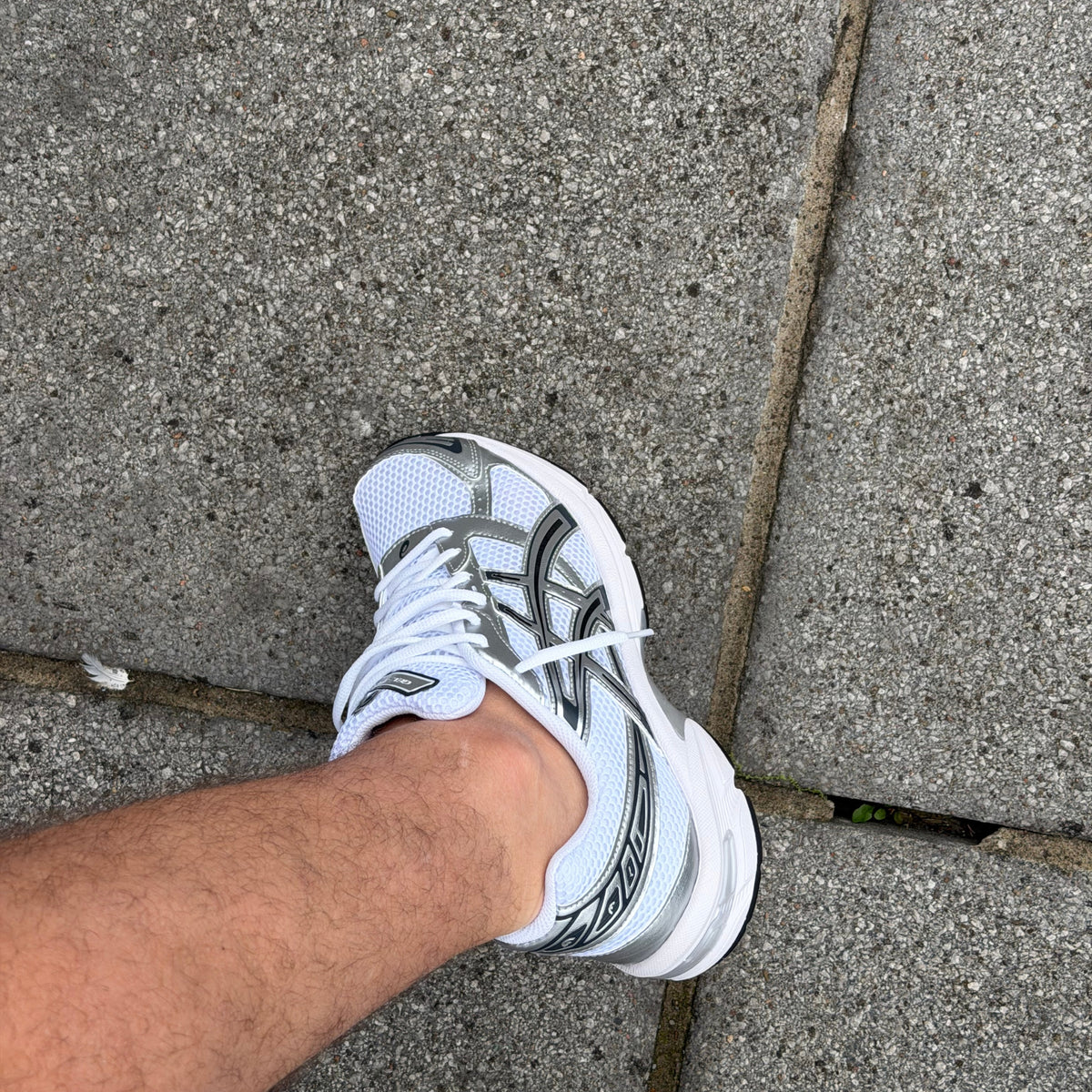 White Pure Silver ASICS Gel-1130 worn outdoors with the metallic side detailing visible