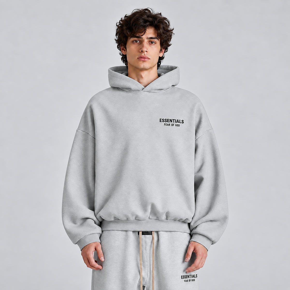 Front detail of Fear of God Essentials Light Heather Grey FW24 hoodie showing chest branding