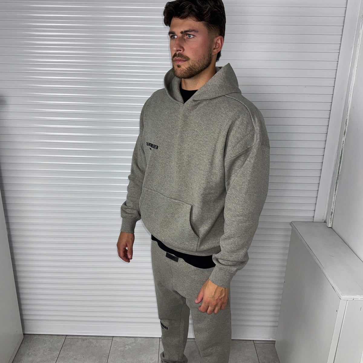 Fear of God Essentials Dark Heather Oatmeal Hoodie worn from the front showing the relaxed fit