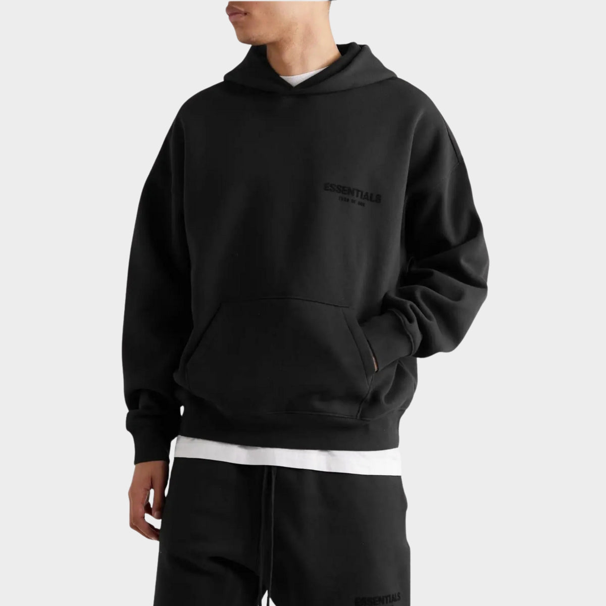 Fear of God Essentials Black Hoodie SS22 styled with black shorts for a casual streetwear outfit