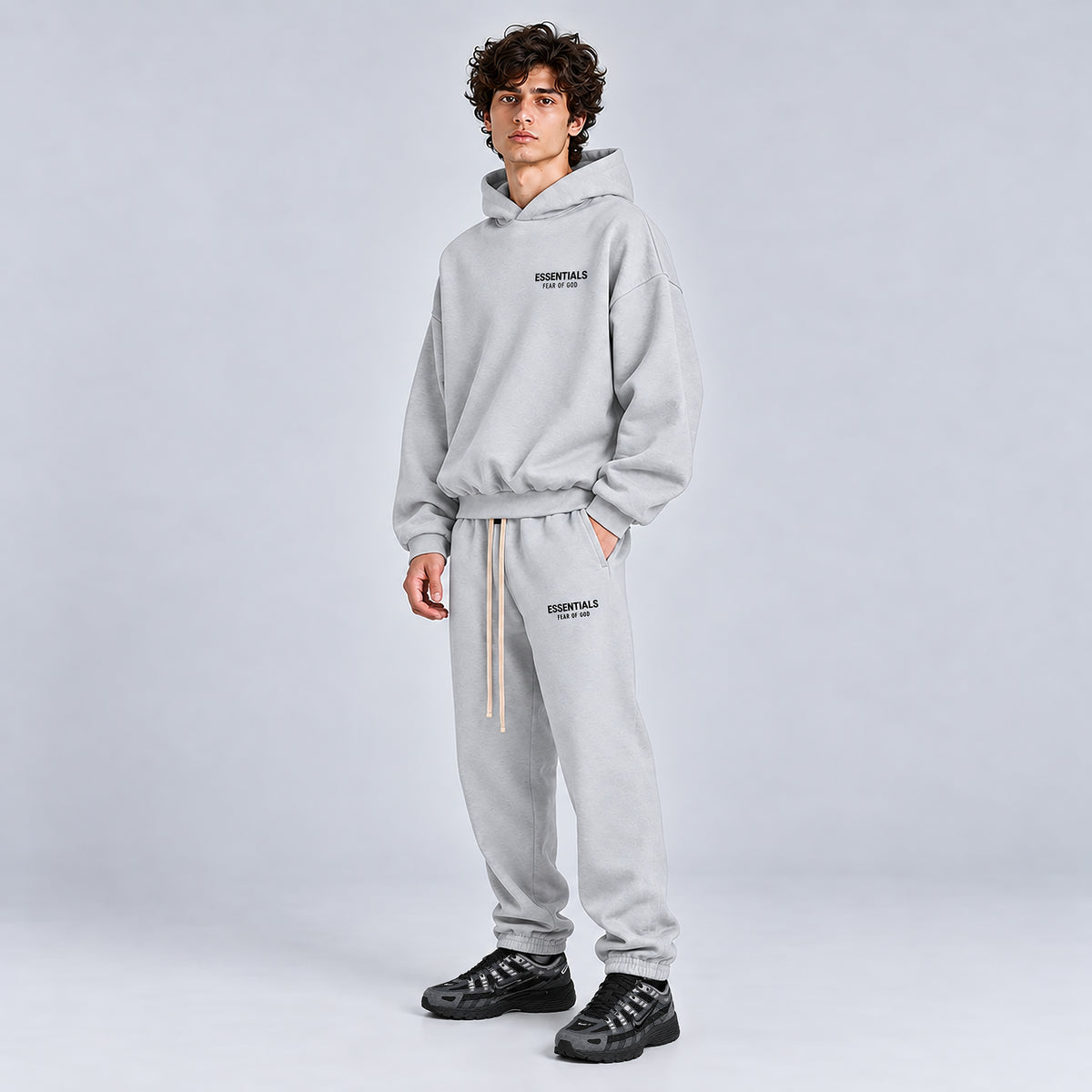 Side view of Fear of God Essentials Light Heather Grey Hoodie FW24 styled with matching sweatpants