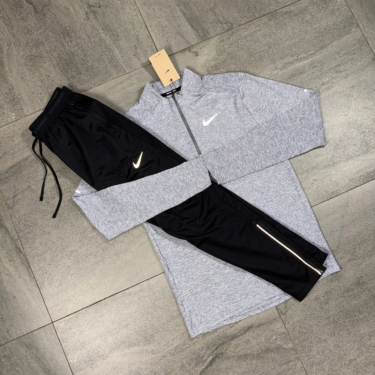 Nike Grey Running Top and Black Phenom Pants flat lay