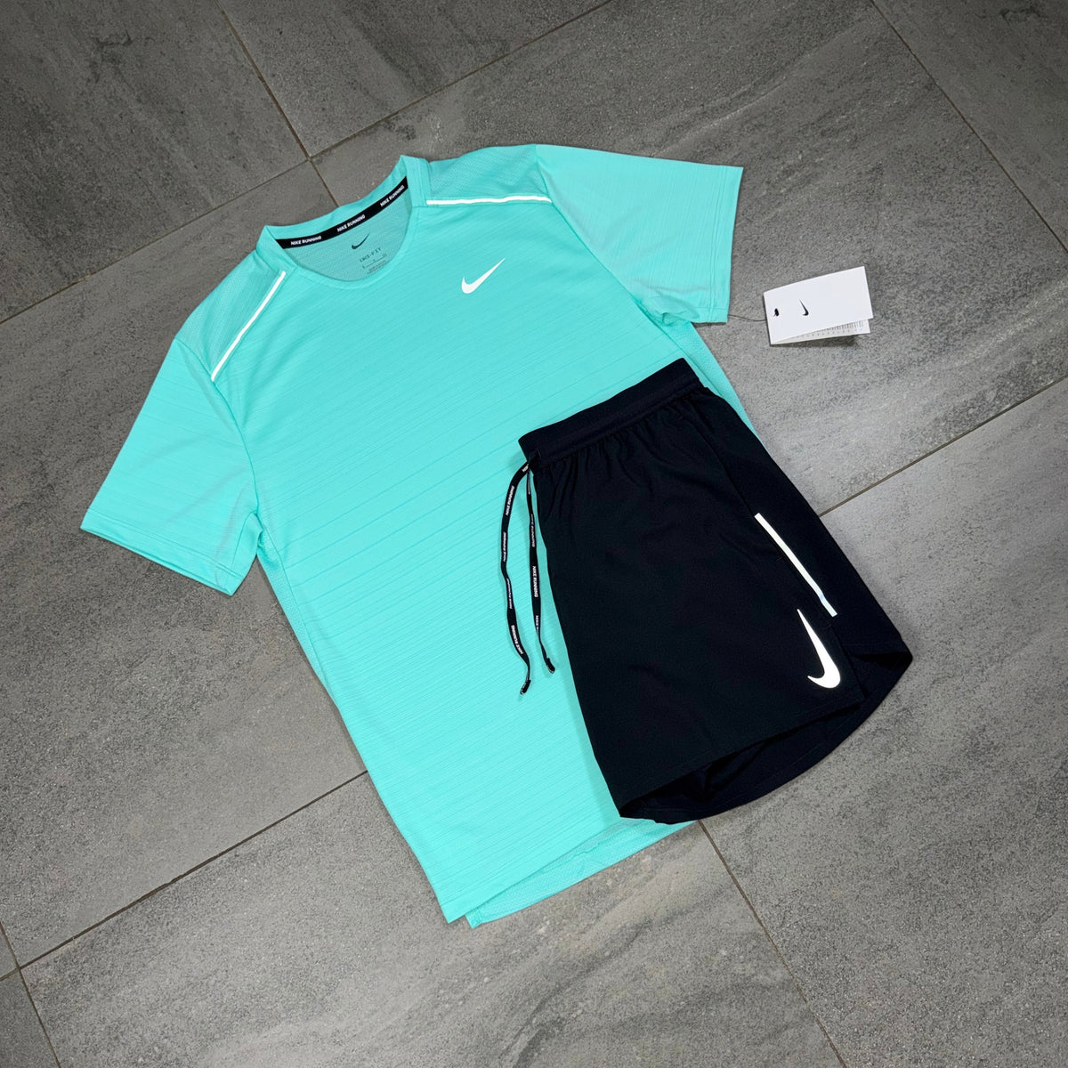 Black Nike OG Flex shorts arranged with a Hyper Turquoise Miler top for a two-piece sportswear outfit