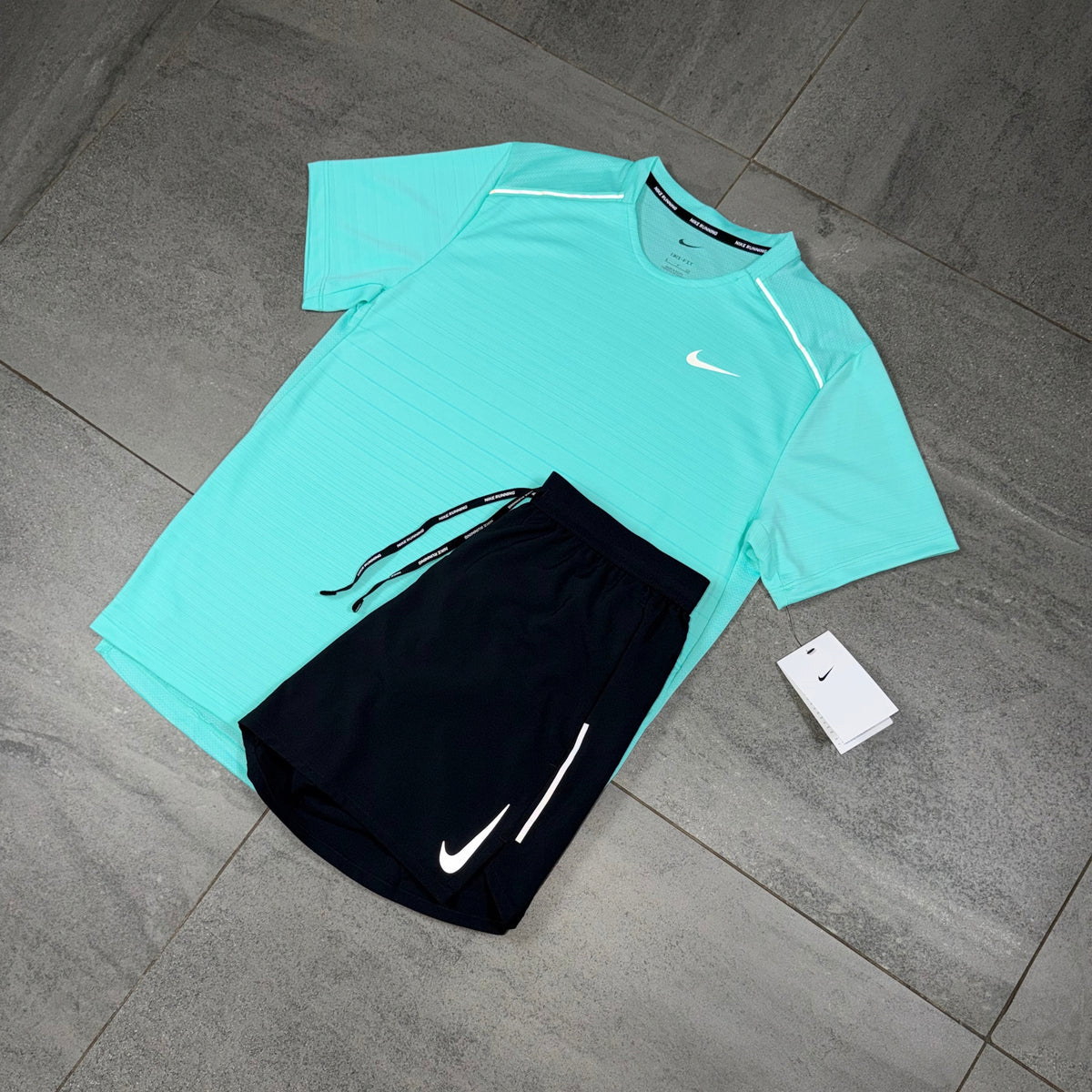 Angled layout of a turquoise Nike Miler performance shirt with black OG Flex running shorts