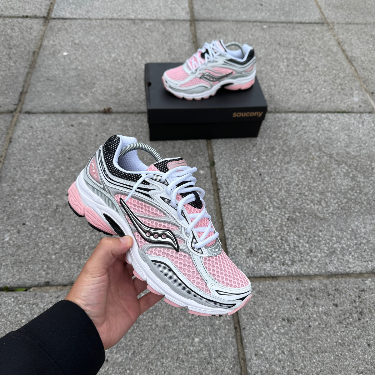 Saucony ProGrid Omni 9 White Touch trainer held in hand