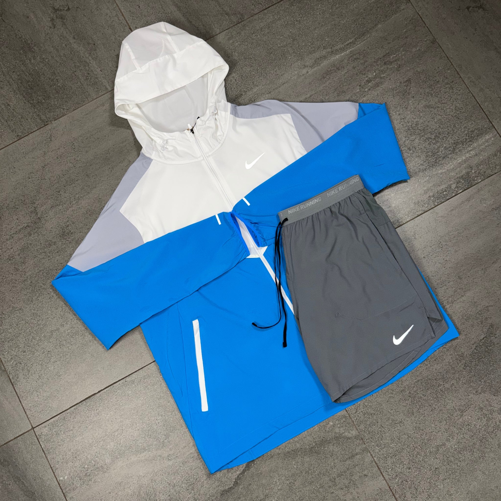 White Wolf Grey Nike Windrunner paired with grey running shorts in flat lay