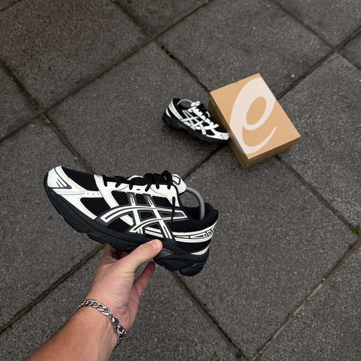 Side profile of ASICS GEL-1130 Black Cream trainers highlighting cream ASICS branding, black mesh and cushioned midsole
