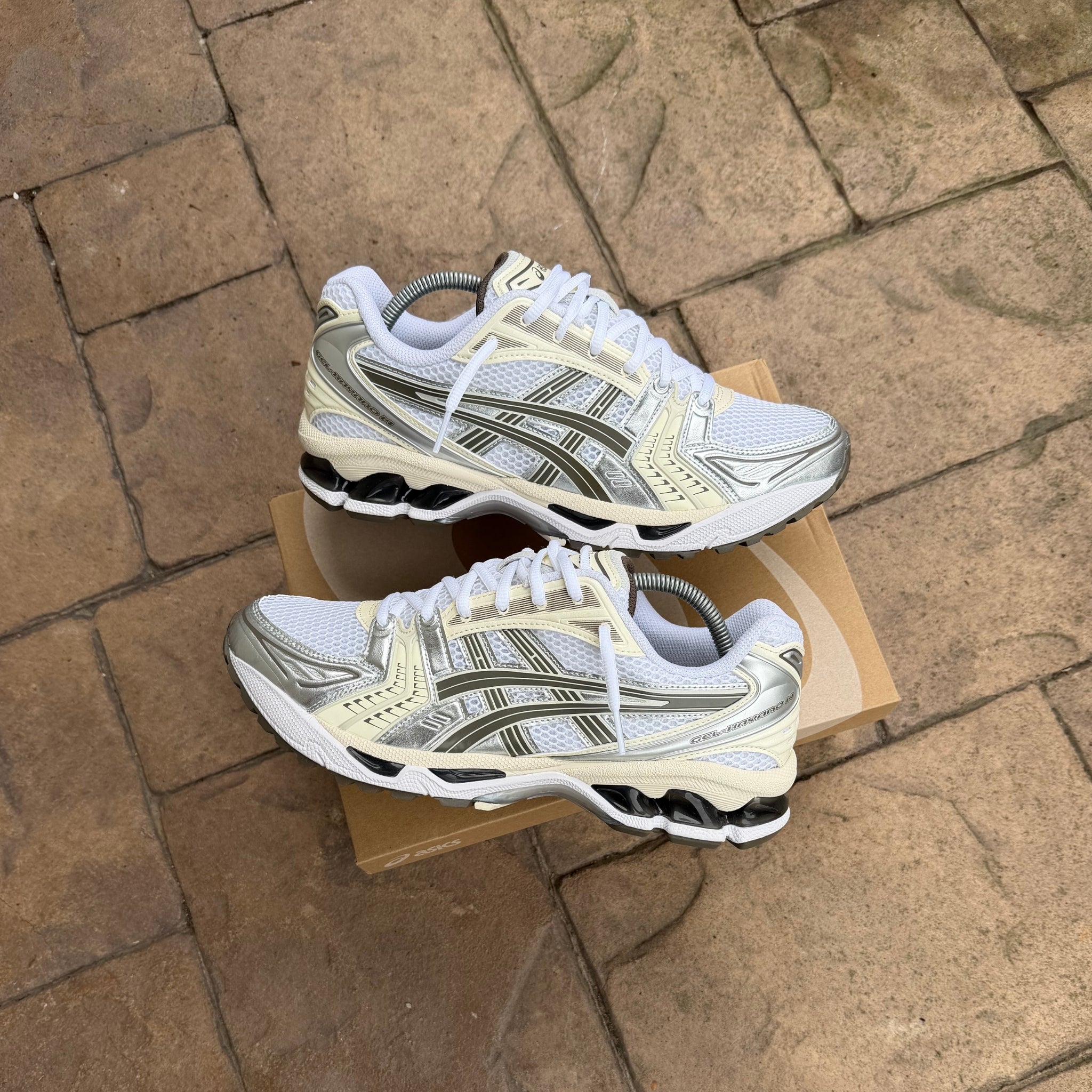 ASICS Gel-Kayano 14 White Ivory trainers held in hand