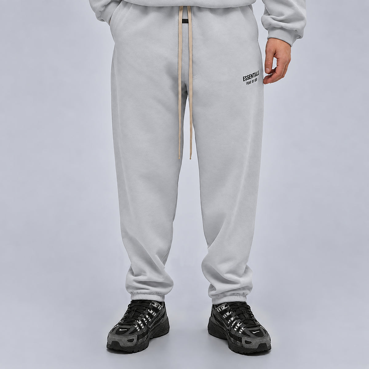 Fear of God Essentials Light Heather Grey Sweatpants FW24 worn from the front