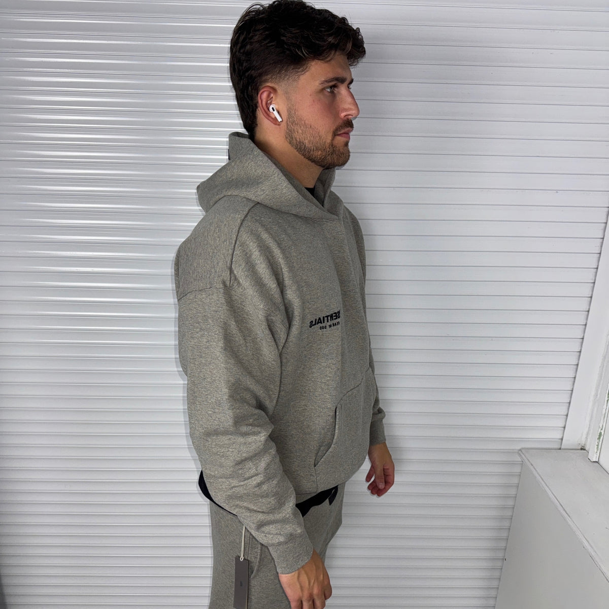 Side view of Fear of God Essentials Dark Heather Oatmeal Hoodie showing the oversized SS22 silhouette