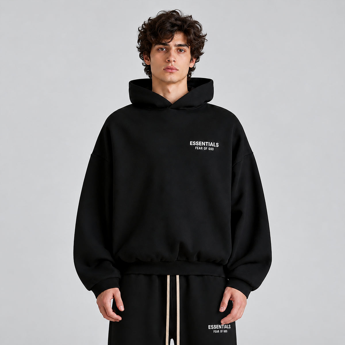 Fear of God Essentials Black Hoodie FW24 worn from the front showing the relaxed oversized fit