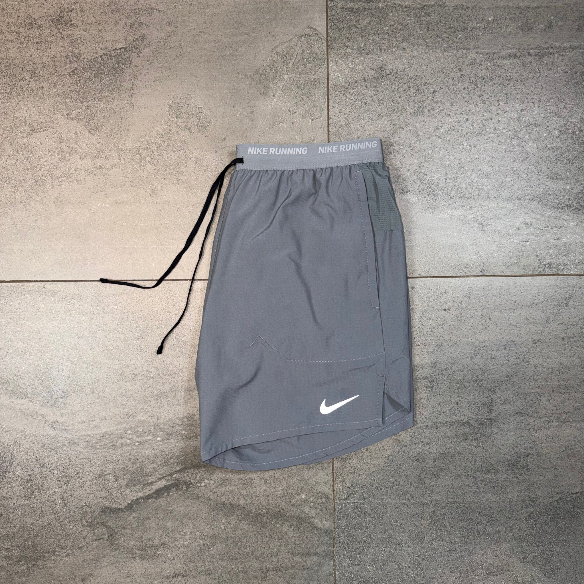 Grey Nike Flex Stride shorts shown separately from the matching Windrunner outfit
