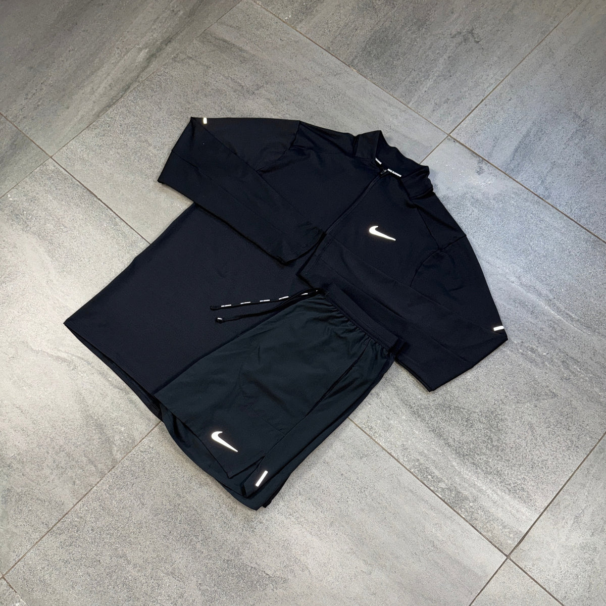 Nike 1/4 Running Top and black Flex Shorts outfit displayed flat