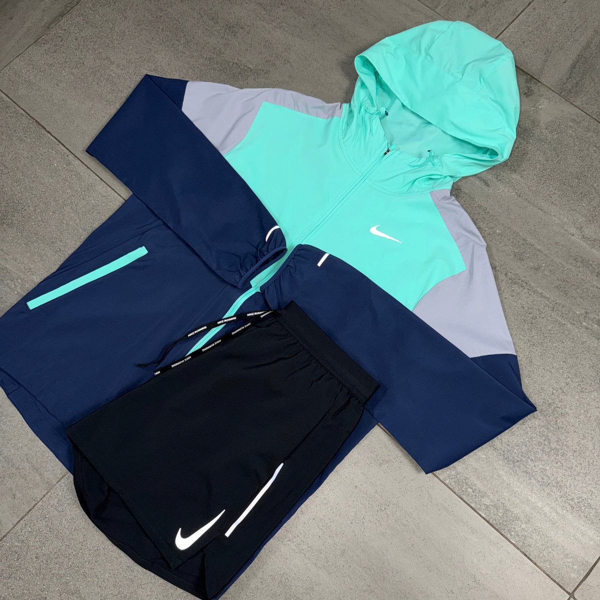 Nike Hyper Turquoise Windrunner Jacket with Black OG Flex Shorts flat lay