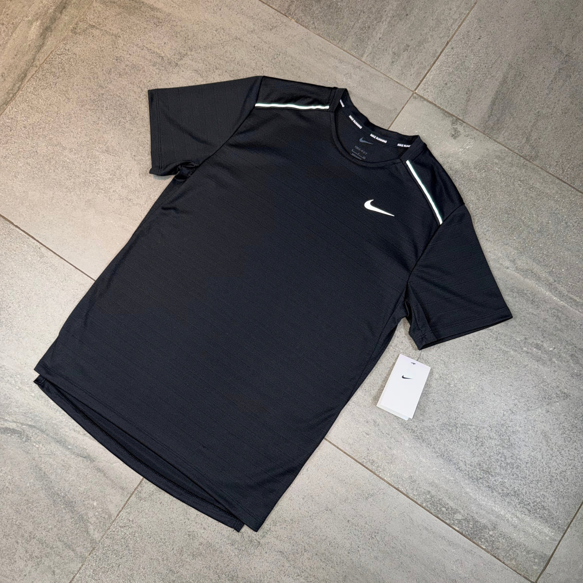 Nike Miler 1.0 Black Dri-FIT T-shirt laid flat showing the front chest branding and short sleeves