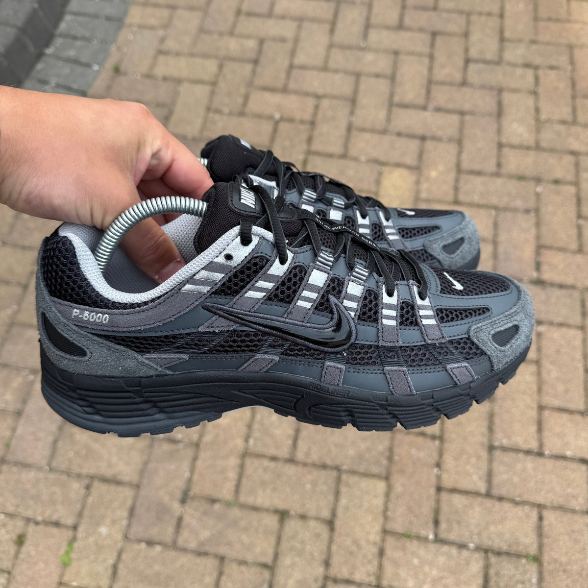 Nike P-6000 Suede Anthracite trainers held in hand