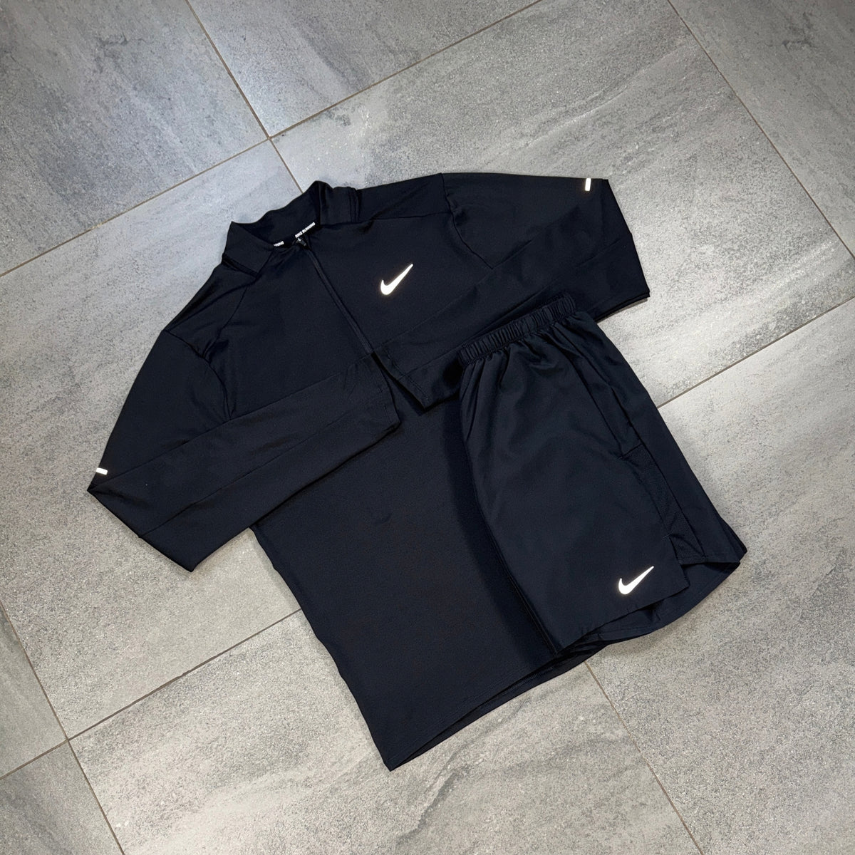 Nike black 1/4 Running Top and Challenger Shorts flat lay