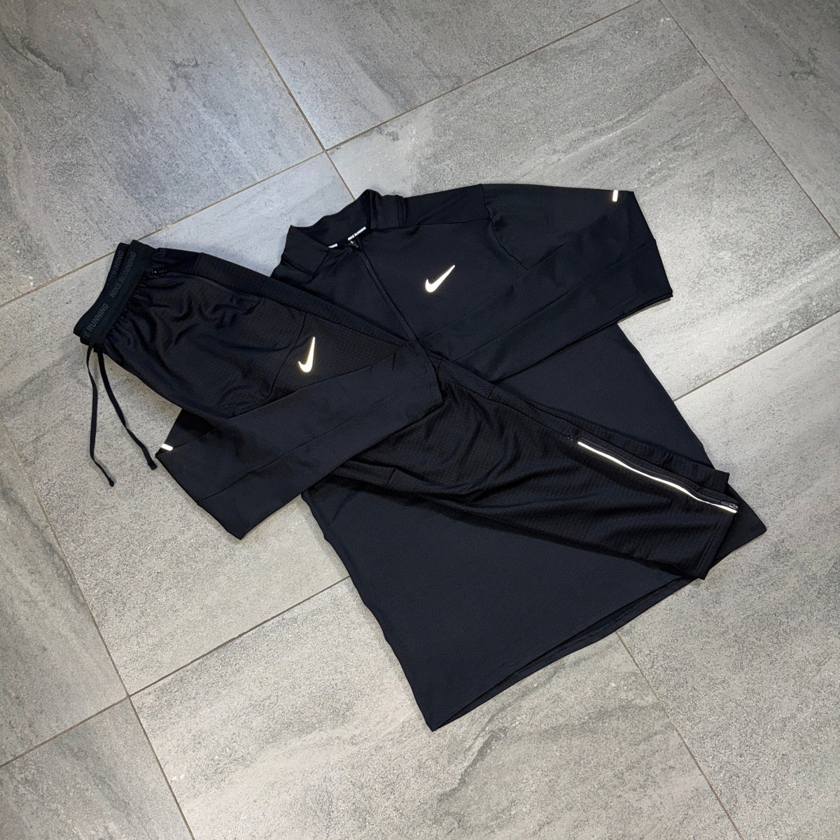 Nike black 1/4 Running Top and Phenom Pants flat lay