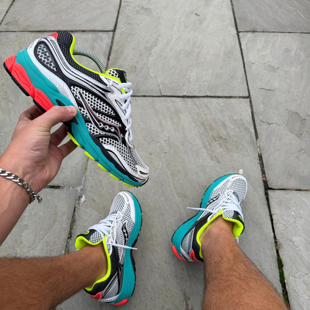 Saucony ProGrid Omni 9 Silver Mutant held in hand showing the side profile and colourful detailing