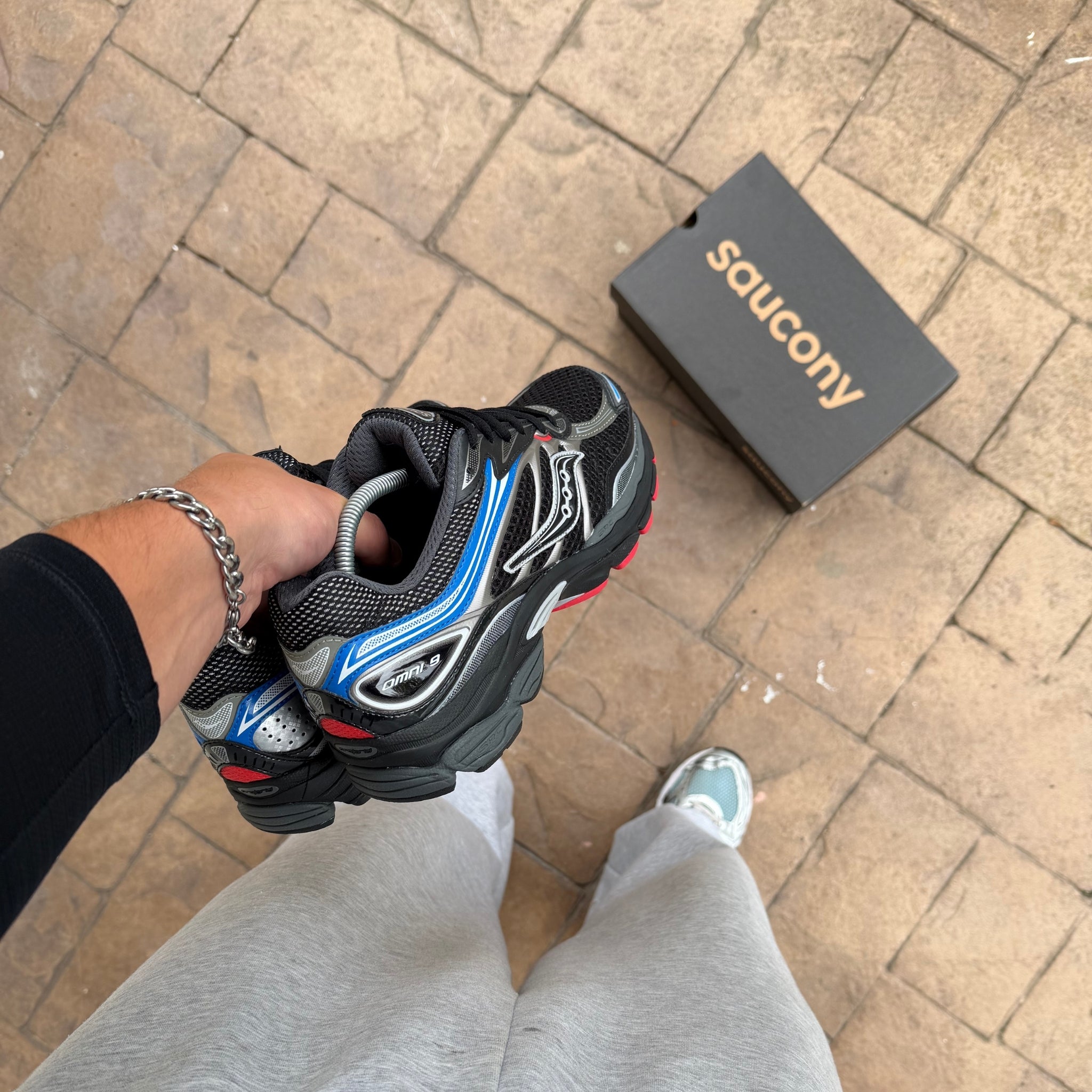 Saucony ProGrid Omni 9 Black Multi trainers held in hand