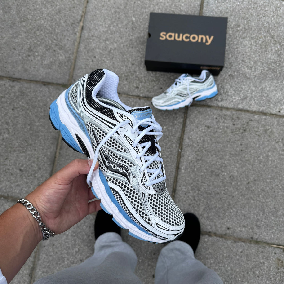 Close side angle of Saucony ProGrid Omni 9 Blissful Blue showing metallic panelling and blue cushioning details