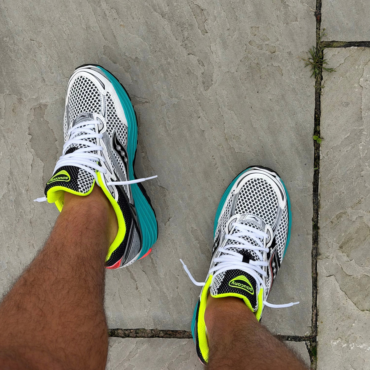 Saucony ProGrid Omni 9 Silver Mutant trainers worn on feet showing the silver and neon colourway