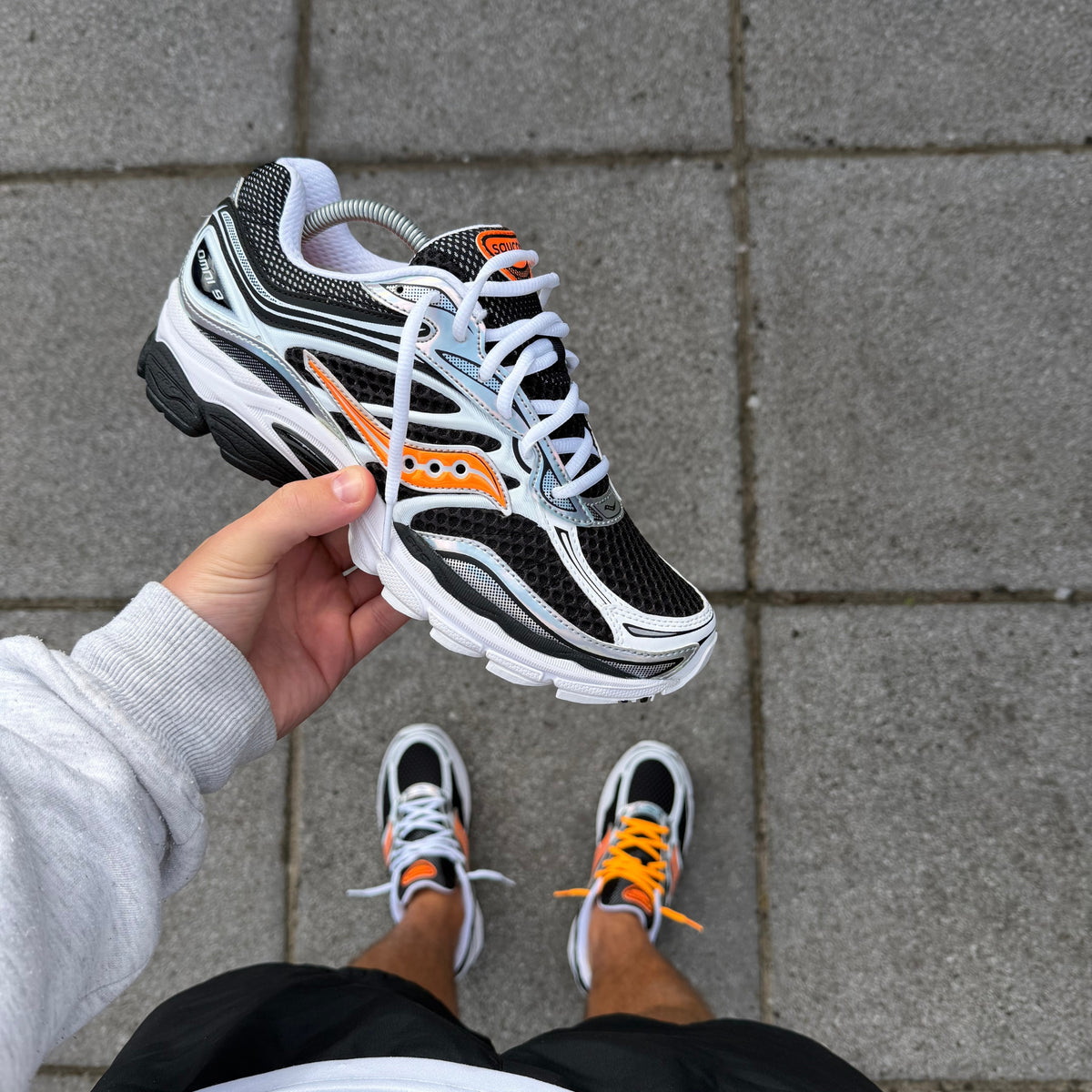 Saucony ProGrid Omni 9 White Orange trainers showing the white, black and orange colourway