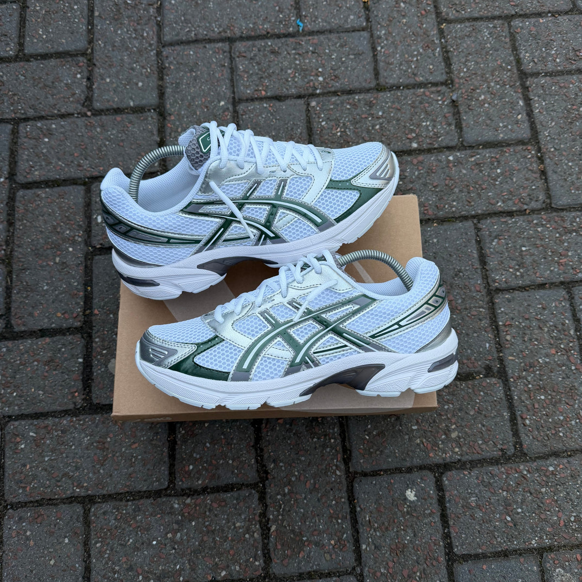 White and green ASICS Gel-1130 trainers on box
