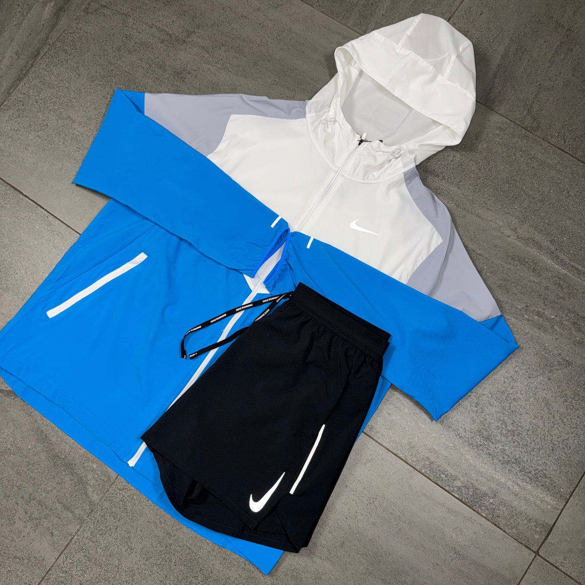 White and blue Nike Windrunner with OG Flex black shorts arranged together